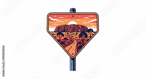 A desert road leads to a massive rock formation at sunset