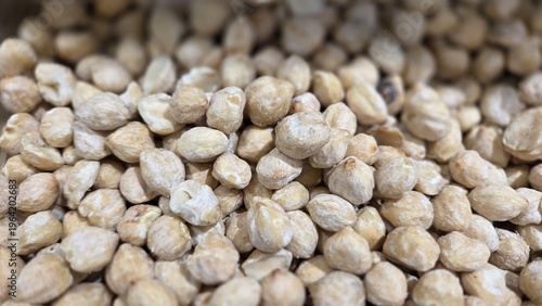 Close-up of dried candlenuts (kemiri) in Indonesian market. Creamy beige nuts with oily texture, widely used as spice base for traditional Indonesian cuisine