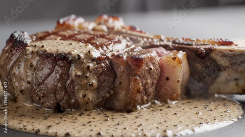 Juicy Bone-In Steak With Creamy Pepper Sauce Being Poured Over It, Close-Up Shot