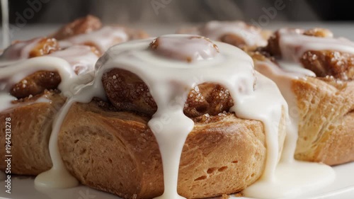 Close-Up of Freshly Baked Cinnamon Rolls Being Drizzled With Icing