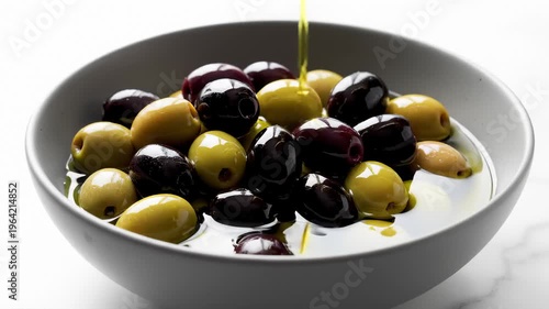 Pouring Olive Oil Over a Bowl of Green and Black Olives in Slow Motion