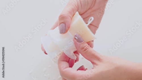 Close-Up of Hands Removing White Candle Wax From Mold During DIY Candle Making Craft Project