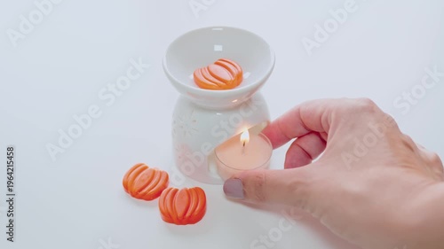 Hand Lighting Tealight Candle Next To Ceramic Wax Melts Oil Burner For Aromatherapy And Relaxation