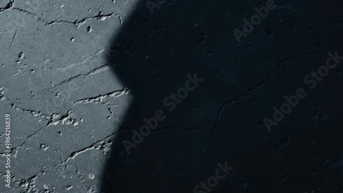 Close-Up of Cracked Concrete Surface With Shadows Moving Across