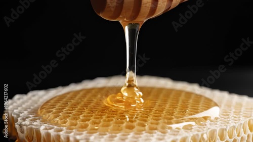 Golden Honey Dripping From Wooden Dipper Onto Fresh Honeycomb