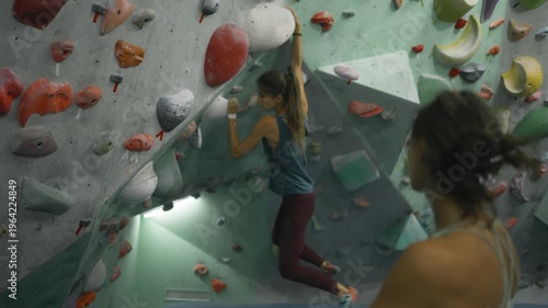 slow motion footage of female rock climber practicing on climbing wall, slow motion shot of woman climbing, extreme sports, bouldering practice . High quality 4k footage