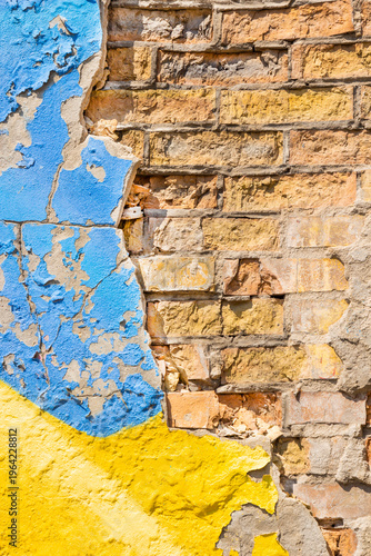 Peeling blue and yellow paint on brickwork. Background