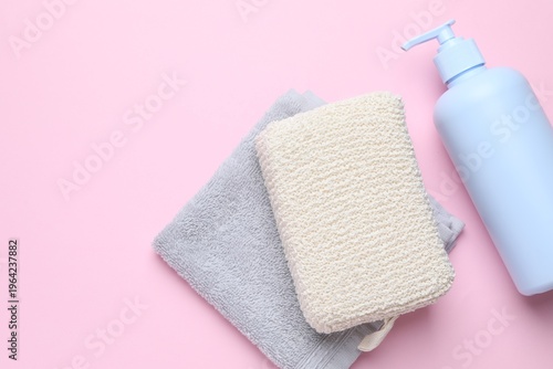 Cuadro en lienzo Natural washcloth, bottle of cosmetic product and towel on pink background, flat lay