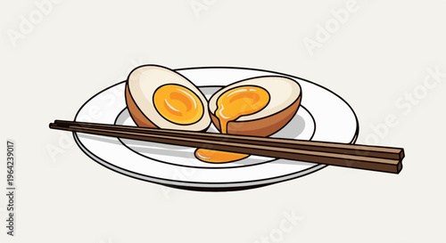 Two halves of a soft-boiled egg with runny yolks on a plate with chopsticks
