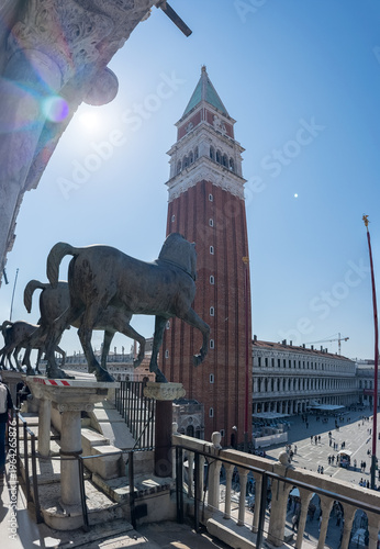 Bronze horses and bell tower in sunny Italian square