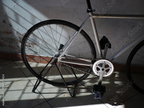 an old white bicycle parked beside the wall
