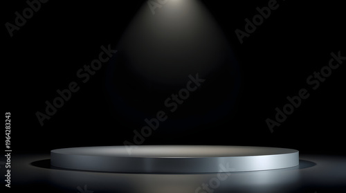 A spotlight shines down on a circular stage in an empty, dark room, ready for a performance or presentation