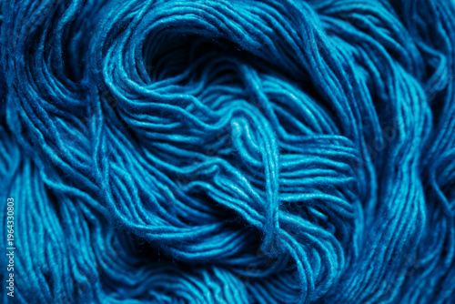Macro shot of deep blue wool yarn in a swirled pattern, rich texture of textile fibers, abstract winter or craft background