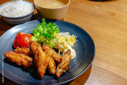 Tableau sur toile 黒い丸皿に唐揚げとサラダが盛られた定食