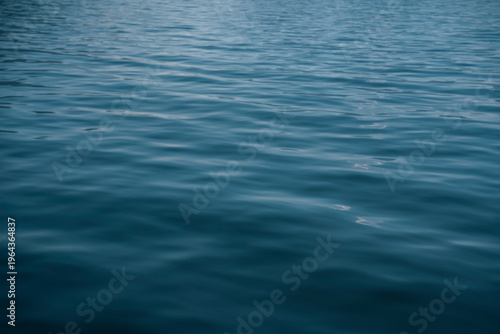 Vibrant serene calm blue sea or lake water surface background captured at the Como Lake in Italy