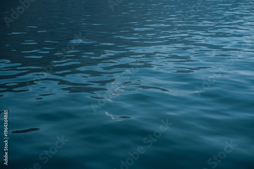 Vibrant serene calm blue sea or lake water surface background captured at the Como Lake in Italy