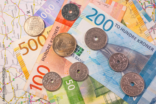 Принти на полотні Scandinavian currency Swedish krona banknotes and coins on travel map representing economy and tourism