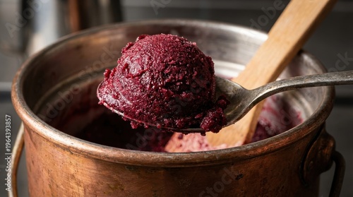 A close-up of a scoop of hand-churned sorbet being lifted from a copper ice cream churn, the texture dense and creamy, small ice crystals catching studio light, the craft of artisan frozen dessert