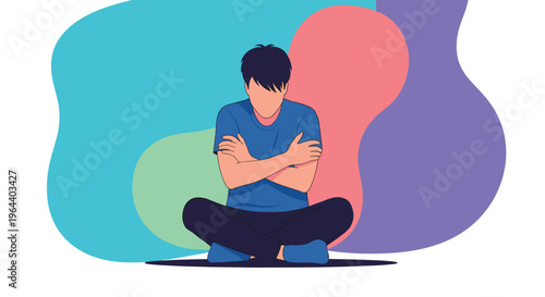 Man sits on the floor cross-legged with his arms tightly crossed and his head bowed in a posture of sadness or defensiveness.