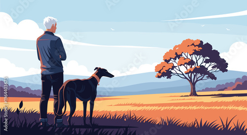 Man standing in an open autumn field with his black greyhound dog looking toward a large tree in the distance.
