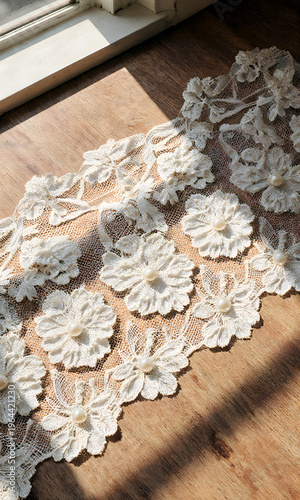 Floral lace fabric laying on wooden surface in natural light - Concept of Bridal Fashion Week  