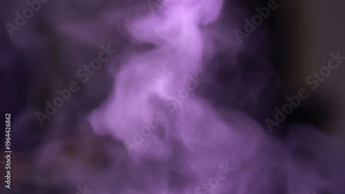 Purple powder explosion forming abstract vibrant pattern concept. Purple smoke or powder cloud swirling in dark background with soft and ethereal texture