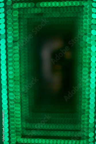 Abstract background of a green bokeh light tunnel.