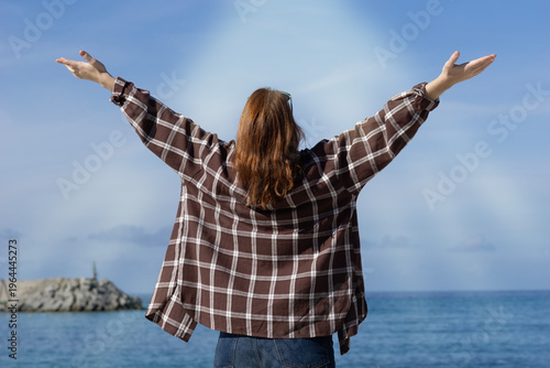 Obraz na plátně young woman worshipping with outstretched arms by the sea peaceful spiritual pos