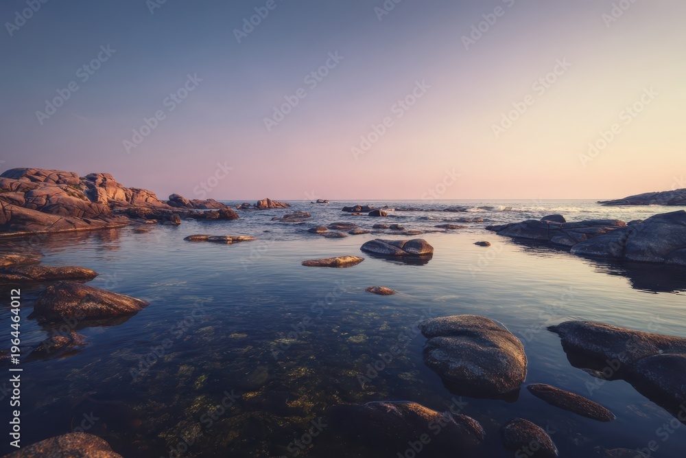 Obraz premium Serene rocky coastline at sunset with calm water and clear sky