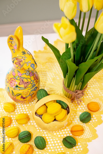 A porcelain basket with baked filled nuts against a background of a vase of yellow tulips and an Easter bunny