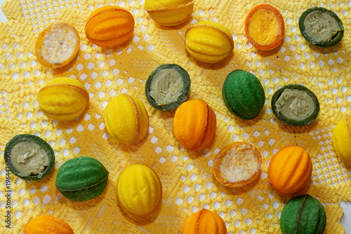 Multicolored cookies with nut-shaped filling on a yellow tablecloth