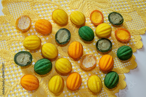 Multicolored cookies with nut-shaped filling on a yellow tablecloth