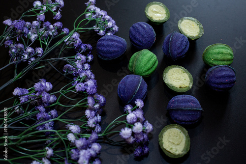 Blue and green baked nuts with cheese filling on a black background with blue wildflowers