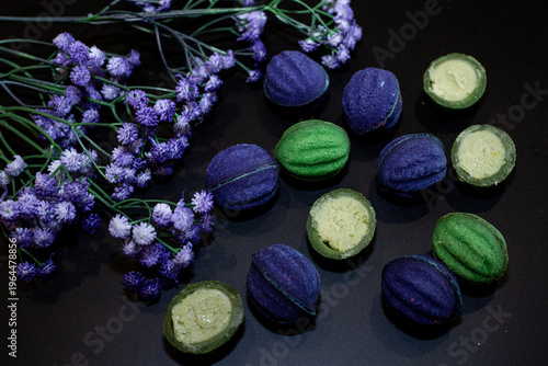 Blue and green baked nuts with cheese filling on a black background with blue wildflowers