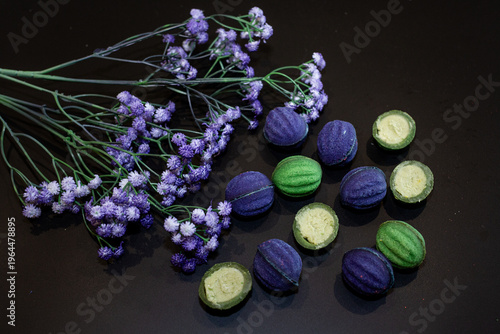 Blue and green baked nuts with cheese filling on a black background with blue wildflowers