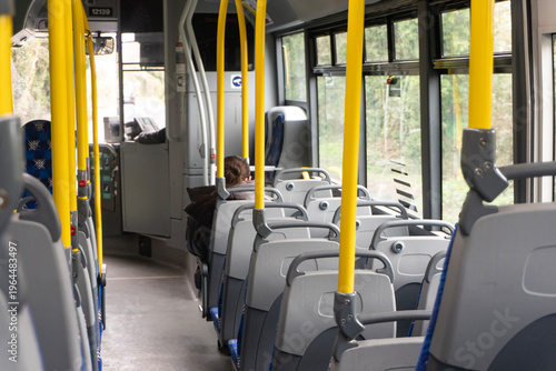 Fotografie Empty public bus interior with yellow handrails and seats, modern urban transpor