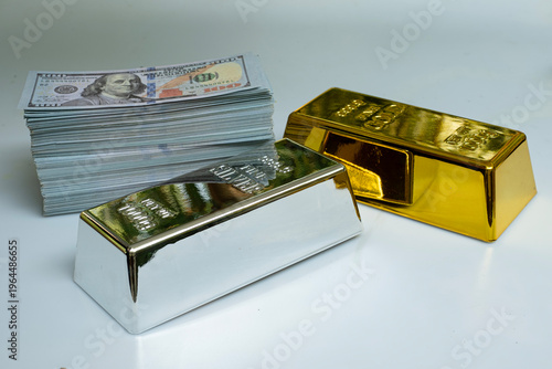 Fine silver gold bar and a pile of money banknote 100 USD on a gray background