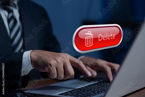 Businessman pushing the delete button on laptop. The concept of deletion or erase contacts, Deleting files from the system. Spam mail, electronic messages or personal data in computer systems.