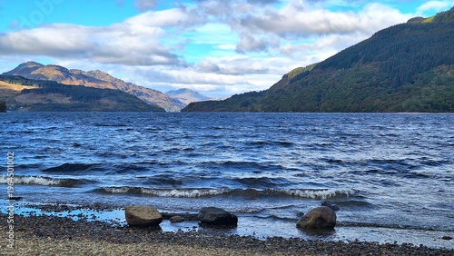 Photos Small waves ripple across Loch Lomond toward a pebbled shoreline at Firkin Point, Scotland