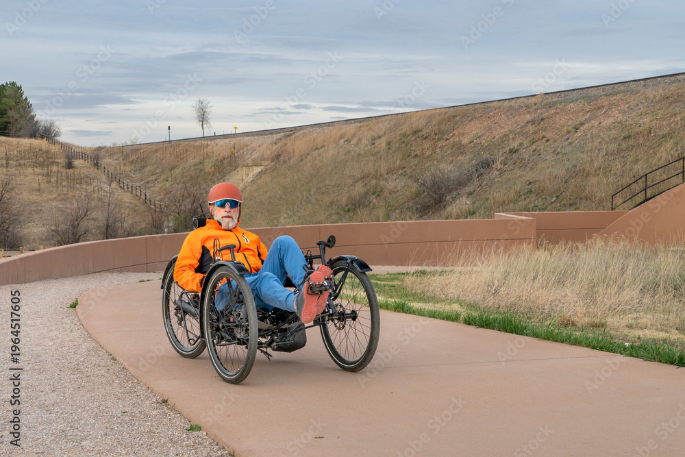 Obraz premium senior cyclist is riding a recumbent tricycle on a paved biking trail in Fort Collins, Colorado