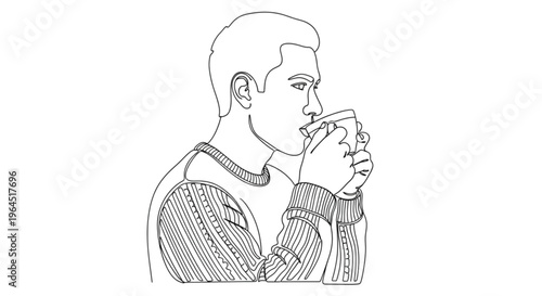 Young man sipping tea while wearing a knitted sweater  