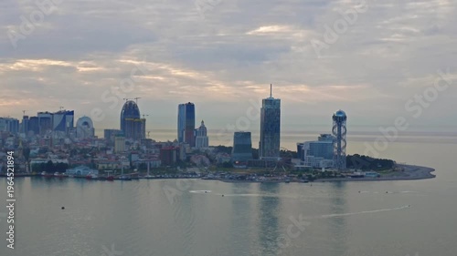 Panoramic aerial of Batumi waterfront with modern architecture and high-rise buildings. Peaceful sea, soft sunset light, and scenic coastal city view in Georgia.