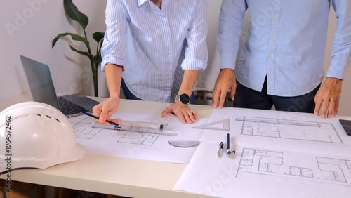 Tableau sur toile Architects and engineers collaborating on a new building design, reviewing bluep