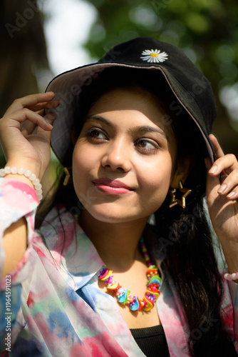 Photos Stylish young Indian woman wearing a casual outfit with a hat and vibrant access