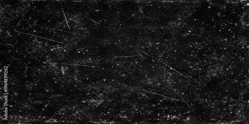 Grungy black background with white scratches and dust particles for a vintage look.