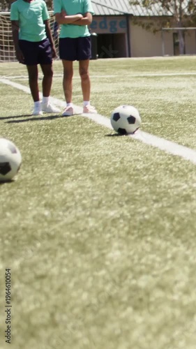 Two youth girls on field line, third running cueing dribbling to goal, graphic path aiding training