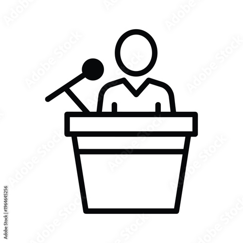Person standing at podium speaking into microphone during presentation or public address event with clear focus