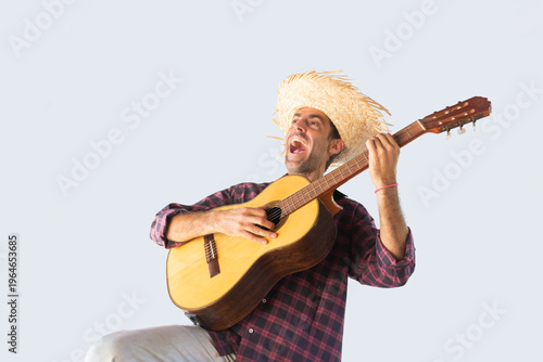 Man dressed for the June festivities singing with a guitar. Isolated