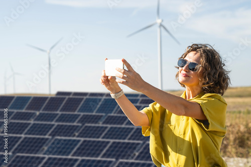 Wallpaper Mural Woman with smartphone at clean energy site solar and wind power farm Torontodigital.ca