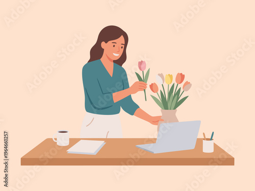 Woman arranging tulips at desk with laptop.